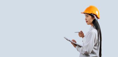 Young female engineer wearing Yellow helmet and clipboard photo