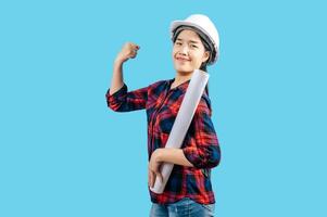 Young female engineer wearing white safety helmet with Blueprints photo