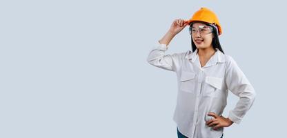Young female engineer wearing yellow helmet stand with charming smile posture photo
