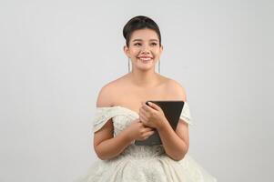 Young asian beautiful bride pose with tablet in hand photo