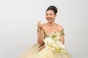 Young asian beautiful bride with orchid bouquet on white background photo