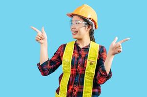 Young female engineer wearing yellow helmet with point finger posture photo