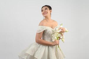 Young asian beautiful bride with orchid bouquet on white background photo