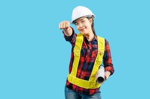 Young asian engineer female wearing safety jacket and helmet raise hand posture photo