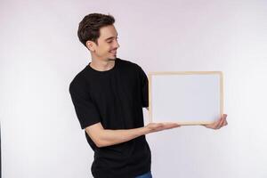 retrato de un hombre feliz que muestra un cartel en blanco sobre un fondo blanco aislado foto