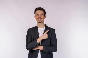 Portrait of young businessman pointing fingers at copy space isolated on white studio background photo