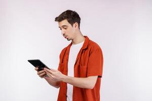 Portrait of attractive cheerful man using device app searching web isolated over white color background photo