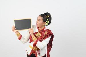 retrato de hermosa tailandés mujer en tradicional ropa posando con pizarra foto