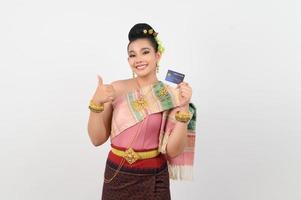 retrato de una hermosa mujer tailandesa con ropa tradicional posando con tarjeta de crédito foto