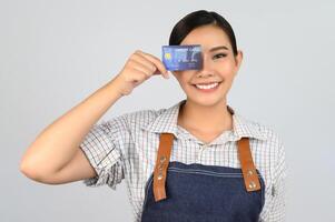 Portrait of young asian woman in waitress uniform pose with credit card photo