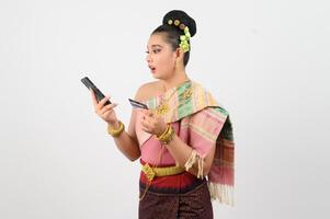 Young beautiful woman in northeastern dress use smartphone and credit card posture photo