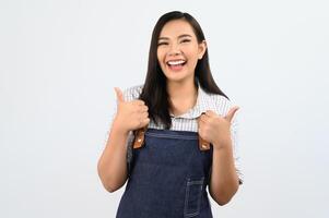 retrato, mujer joven asiática, en, camarera, uniforme, con, pulgar up, postura foto