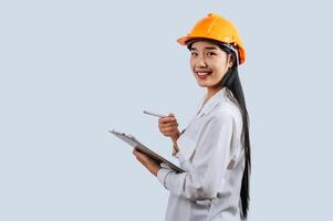 Young female engineer wearing Yellow helmet and clipboard photo