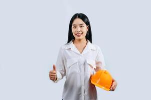 Young female engineer in helmet stand with thumb up posture photo