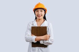 Young female engineer wearing Yellow helmet and clipboard photo