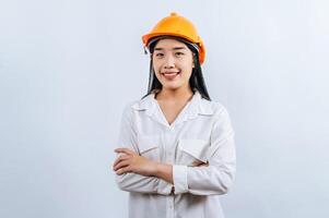 joven hembra ingeniero vistiendo amarillo casco estar con encantador sonrisa postura foto