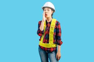 Young female engineer wearing yellow helmet with shouting posture photo