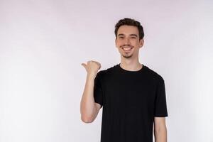 Portrait of young man pointing fingers at copy space isolated on white studio background photo