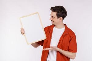 Portrait of happy man showing blank signboard on isolated white background photo