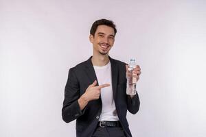 Portrait of Happy young man showing water in a bottle isolated over white background photo