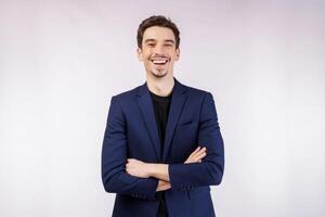 Portrait of young handsome businessman wearing suit standing with crossed arms with isolated on studio white background photo