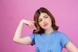 retrato de una joven que lleva una camiseta informal pensando e imaginando aislada sobre un fondo rosa foto