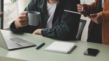 Financial analysts analyze business financial reports on a digital tablet planning investment project during a discussion at a meeting of corporate showing the results of their successful teamwork. video