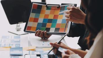 Close up ux developer and ui designer brainstorming about mobile app interface wireframe design on table with customer breif and color code at modern office.Creative digital development agency video