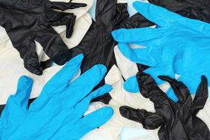 lote de proteccion elástico quirúrgico guantes blanco, negro y azul colores. plano laico de cerca ver de higiene y protector guantes foto