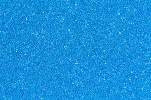 Foam sponge porous texture background deep sky blue color. Extreme close-up view of unique detail abstract synthetic material. Horizontal composition for design, colored decoration backdrop photo