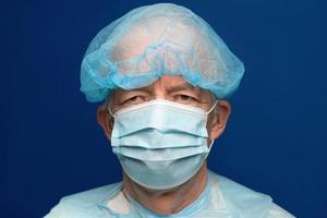 Portrait of senior adult dressed in surgical face mask, covering nose and mouth from SARS, virulently infectious disease corona virus photo