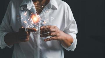 Female holding lightbulb showing graduation hat, Internet education course degree, study knowledge to creative thinking idea and solving solution. E-learning graduate certificate program concept. photo