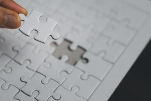 Business woman person hand holding puzzle piece idea for strategy and solution. Closeup part of one white jigsaw connect together. Concept of join cooperation success teamwork-problem corporate team photo