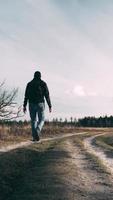 hombre caminando abajo un camino en el bosque video