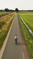 Aerial view of a cyclist riding down a long country road video