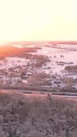 Bird's eye view of paved road over snowy grass fields video