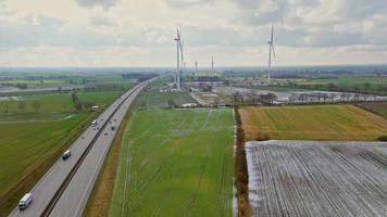 Visualizza a partire dal sopra su il Tedesco autostrada a7 con alcuni mulini a vento per rinnovabile elettricità sotto costruzione. video