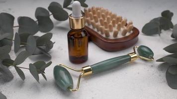 Spa treatment concept. natural spa cosmetics products with eucalyptus oil, massage brush, eucalyptus leaf. video