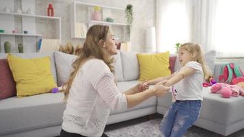 mãe e pequeno filha abraçando. a mãe abraçando e se beijando dela filha às casa é feliz. video