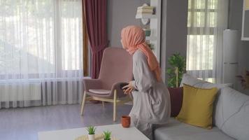 jung Muslim Frau beim heim. das jung Frau tragen ein Kopftuch ist Gehen um das Haus. video