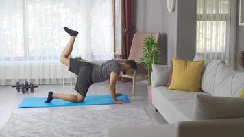 Man exercises, burns fat, burns calories, strength training, home fitness. Mid adult fitness man exercising at home. video