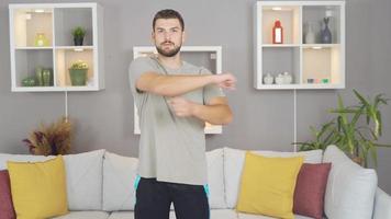 atleta homem fazendo exercícios às lar. homem fazendo Esportes às casa fazendo aquecer exercícios. video