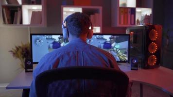 Professional eSports Player playing Video game on his Computer. A young man playing a video game inside a room.