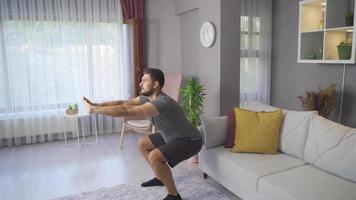 sportlich Mann üben Yoga zum gesund Rücken und produktiv Tag. jung Mann ausüben beim Zuhause tut Ausfallschritt Hocken Übung.