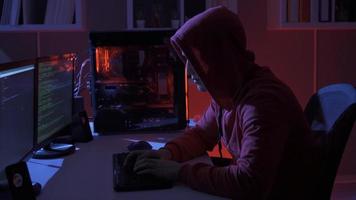 Hacker. Hacker Sitzung in der Nähe von Computer Monitore mit Grün Code Bildschirme. video