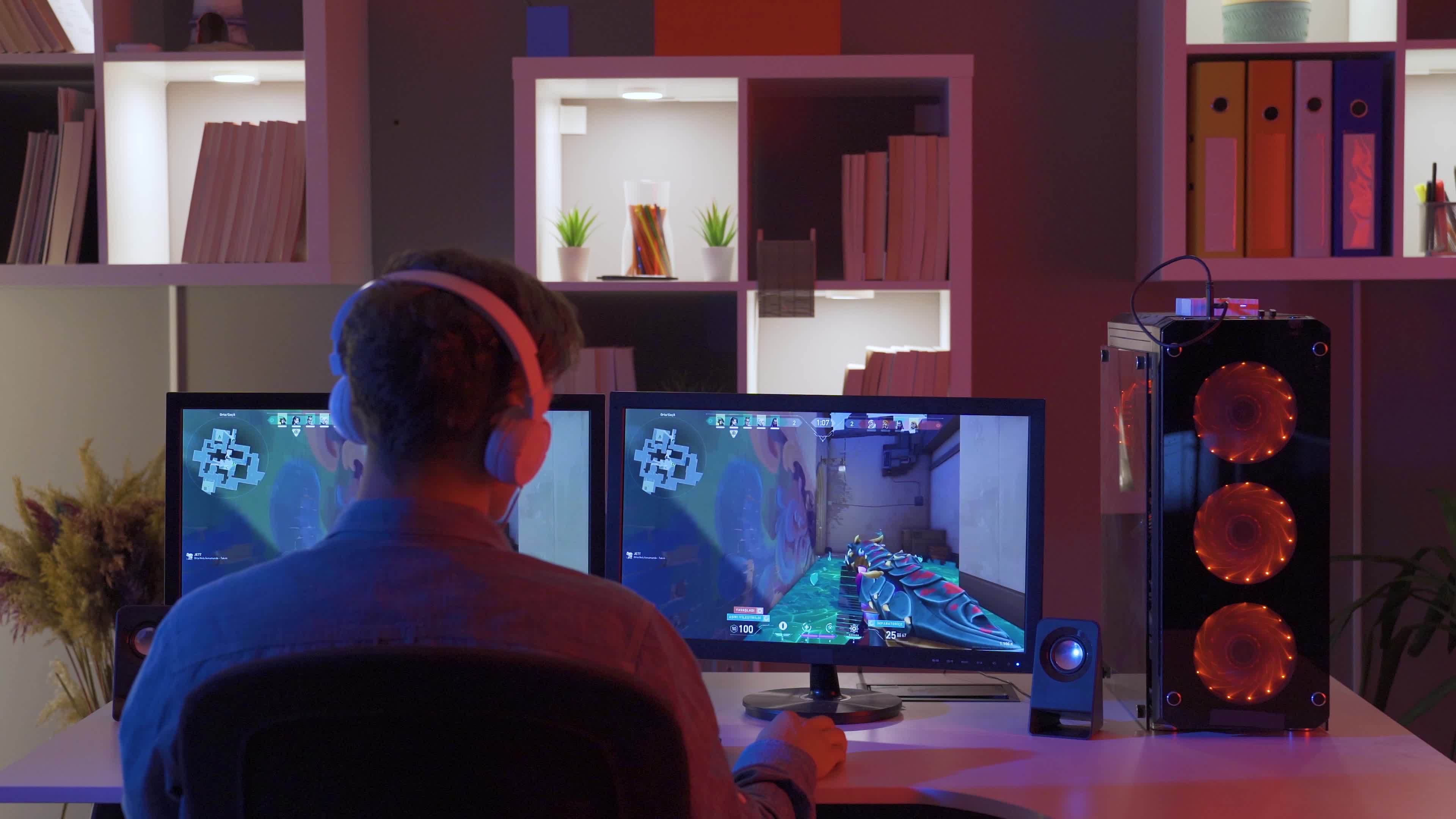 Young boy playing a game sitting in front of a computer, wearing ...