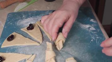 Women's hands wrap cherry filling in dough while preparing homemade sweets. video