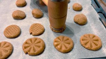 appliquer une modèle avec une spécial outil sur fait maison biscuits avant cuisson eux. video