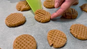 Women's hands straighten cookies lying on parchment paper before baking. video