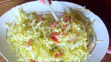 Mixing fresh vegetable salad lying in a plate. video